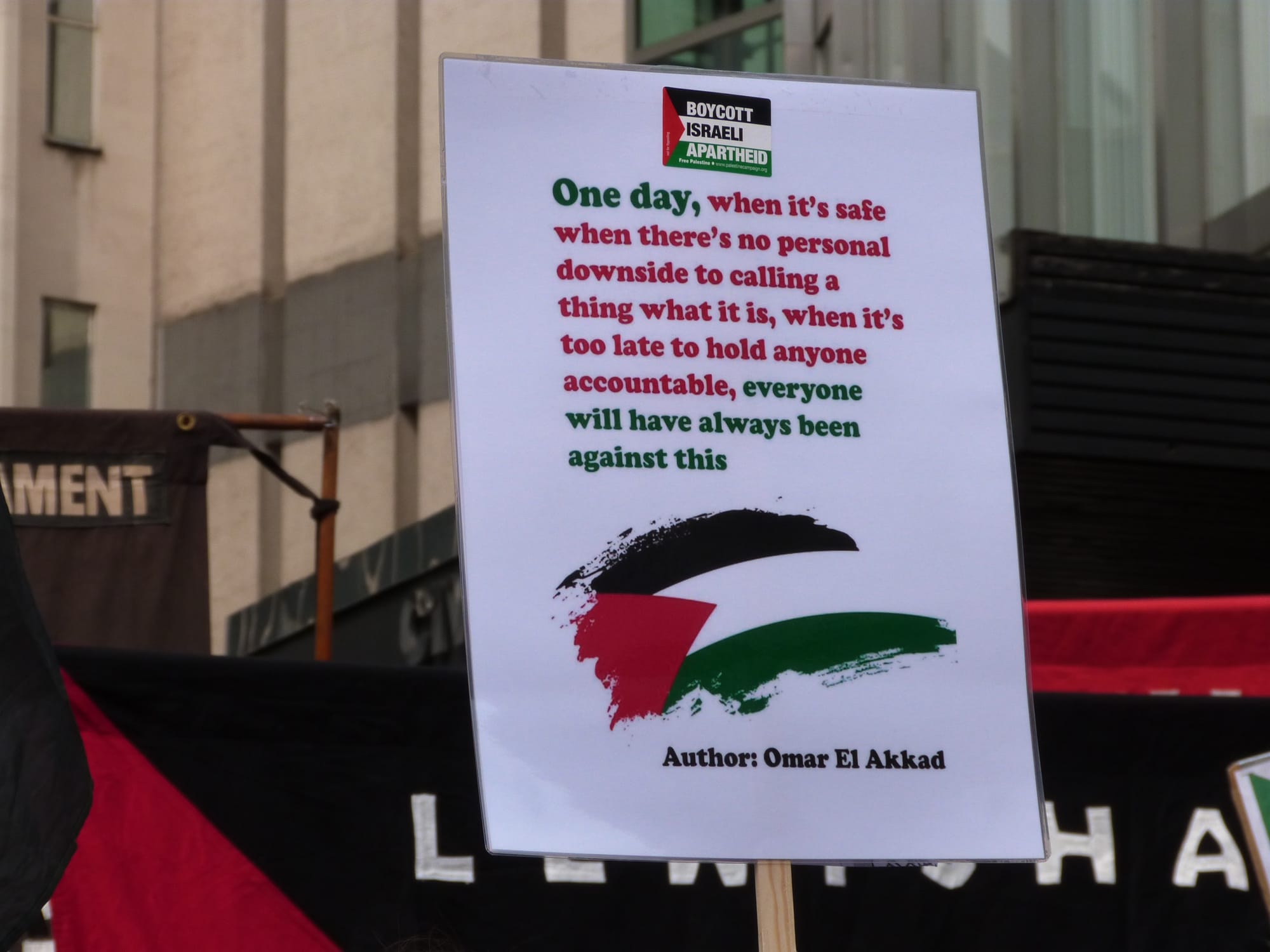 Sign with quote: "One day, when its safe and there's no personal downside to calling a thing what it is, when it's too late the hold anyone accountable, everyone will have always been against this." Author: Omar El Akkad