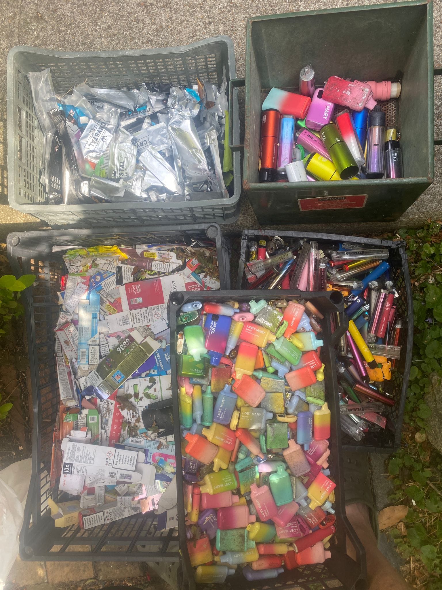 The combined haul - disposable vapes and packaging sorted into crates.