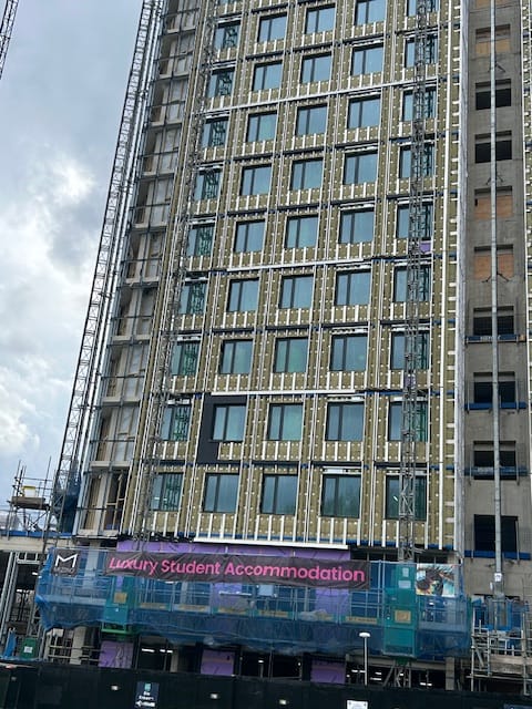 Tower block under development with banner on scaffolding: Luxury Student Accommodation. 35% affordable student rooms planned