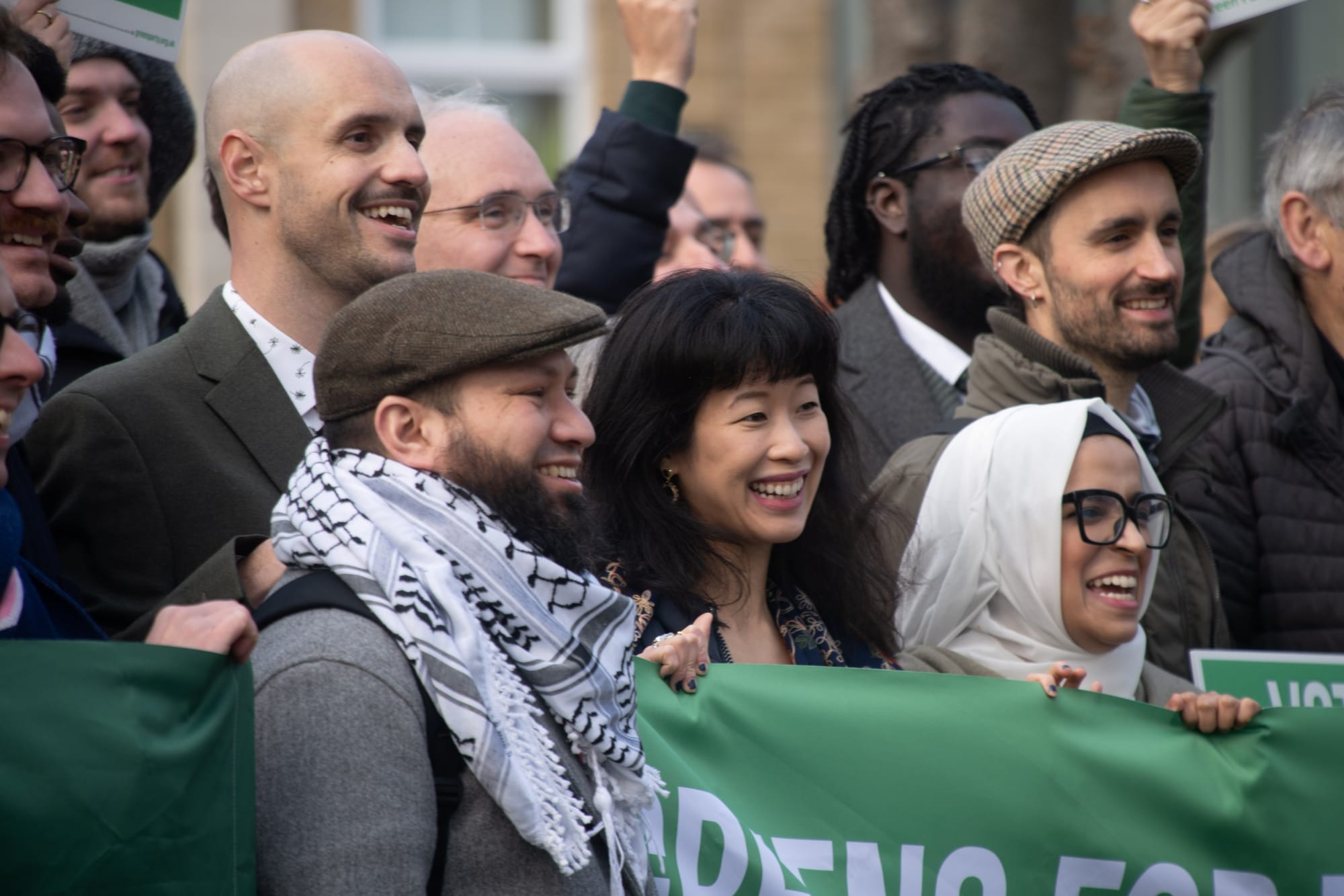 Liam Shrivastava, Mothin Ali, Hau-Yu Tam smiling, with Green Party supporters