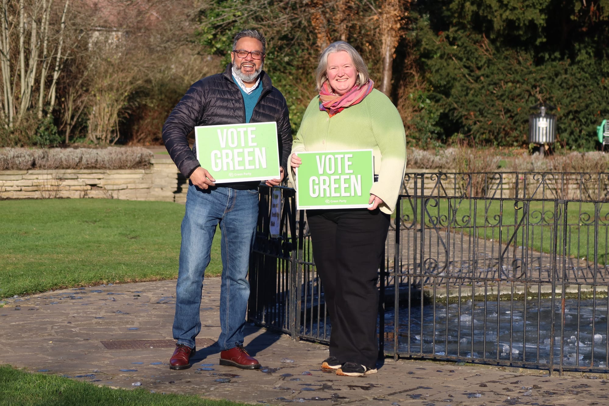Councillors Saldin and Rhymes holding 'Vote Green' placards.