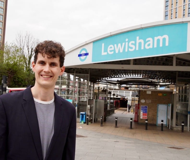 Josh Matthews smiling, standing at Lewisham station.