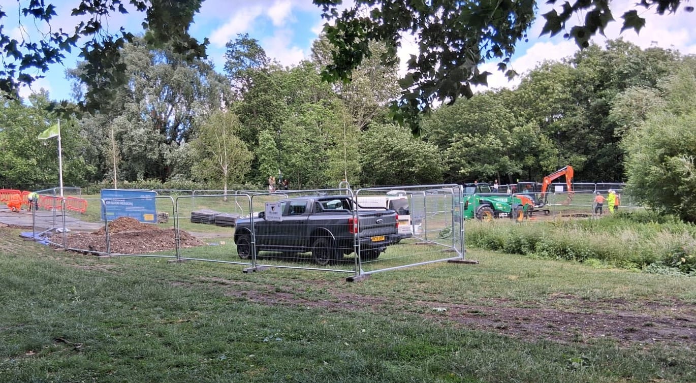  heavy machinery and diggers behind fencing in the park.