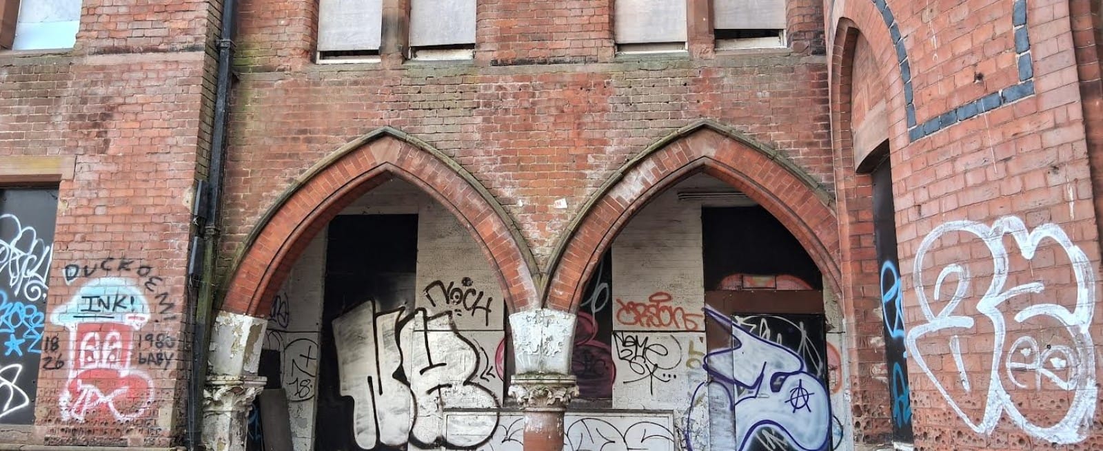 Playtower entrance, towo brick arches, covered in grafitti. 