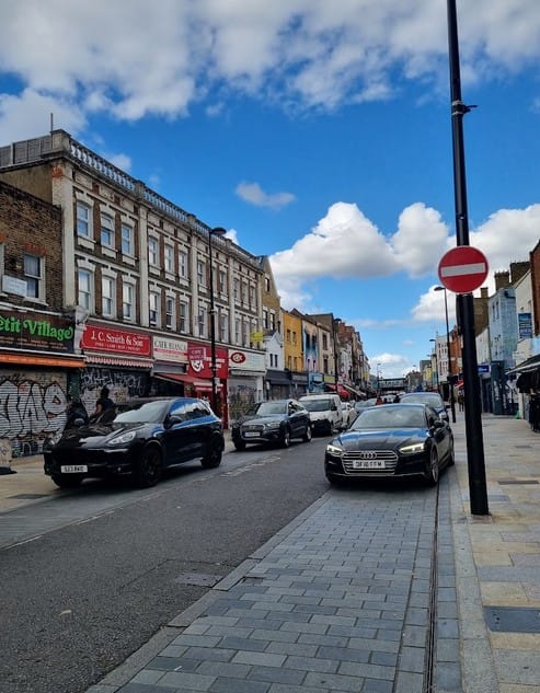 No CPZ, no protected routes - cars parked both sides of road and on pavement on Deptford High Street.