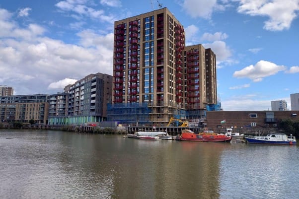 3 new towers built at edge of creek, boats at riverside.