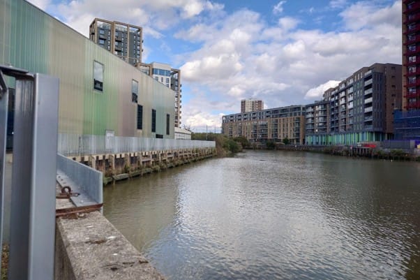 The creek walled in by concrete walls with intertidal habitats visible as built in shelves.