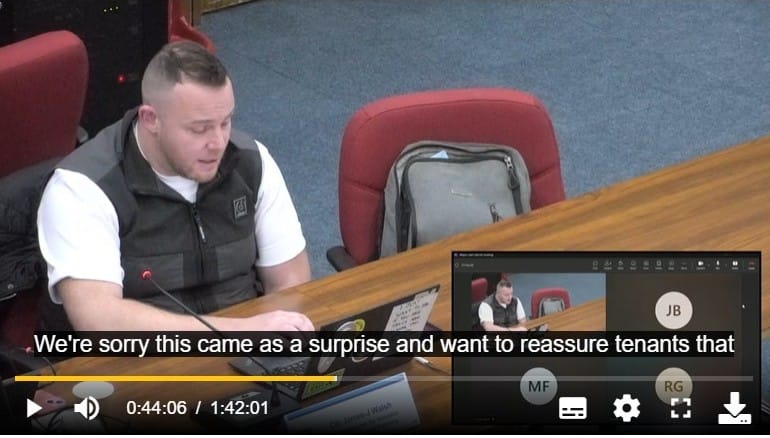 Councillor speaking while reading laptop, with subtitles: "We're sorry this came as a surprise and want to reassure tenants that .."