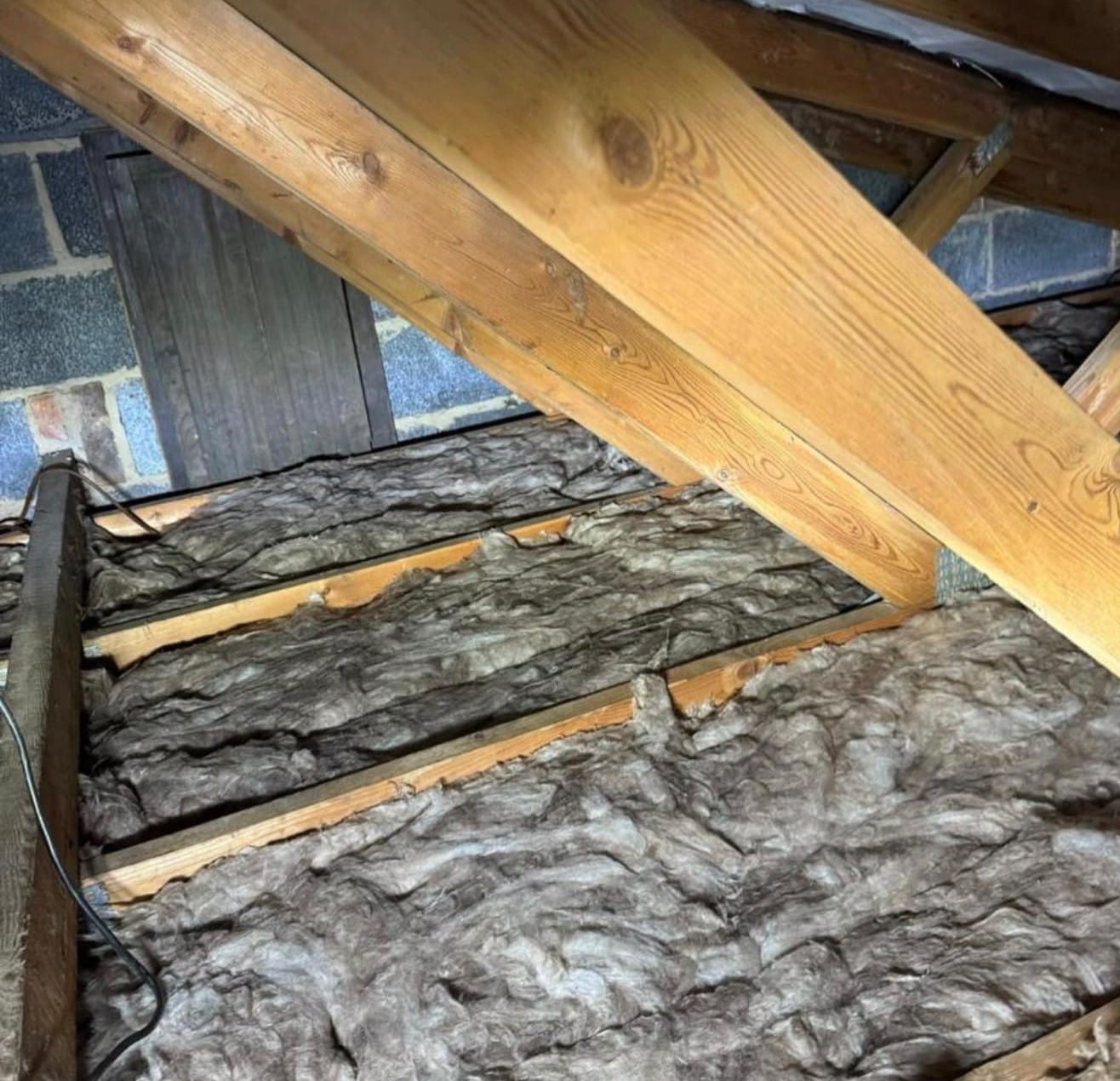 Picture of loft space, area between joists filled with insulation. 