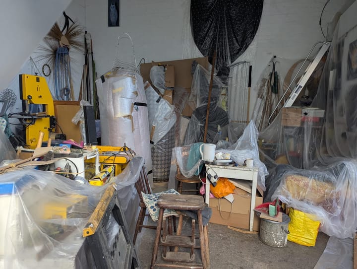 Packed up artists studio, objects covered in plastic sheeting
