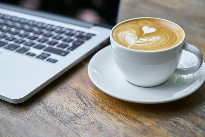 Cappucino next to laptop