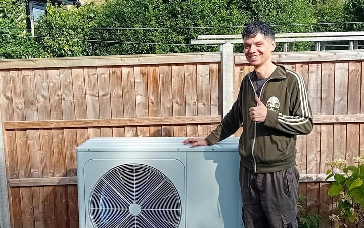 Andy standing by heat pump in the garden