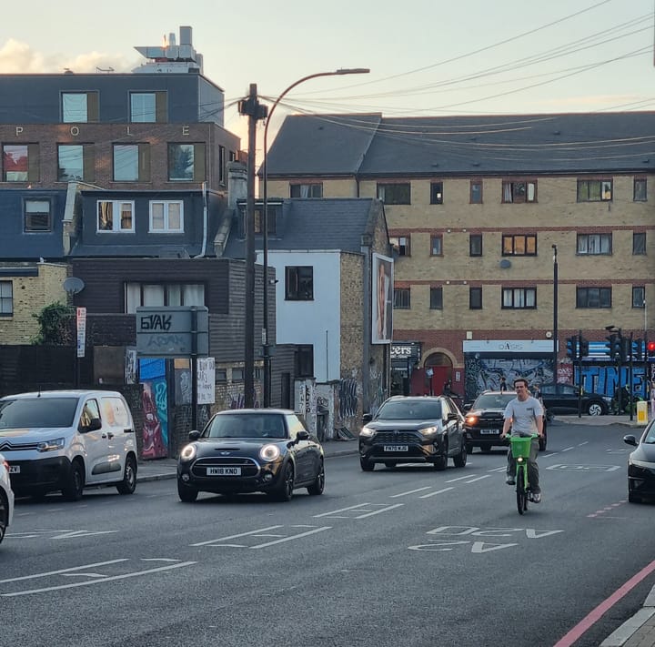 Cyclist negotiating heavy traffic at Amersham gyratory, an accident blackspot at New Cross, Lewisham