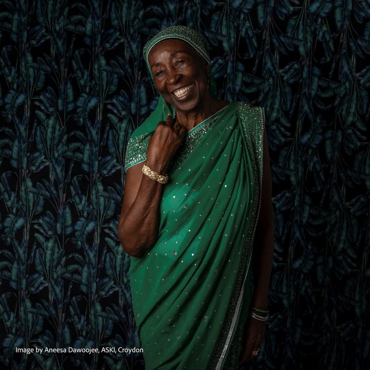 Workshop participant beaming with joy in green sparkling sari