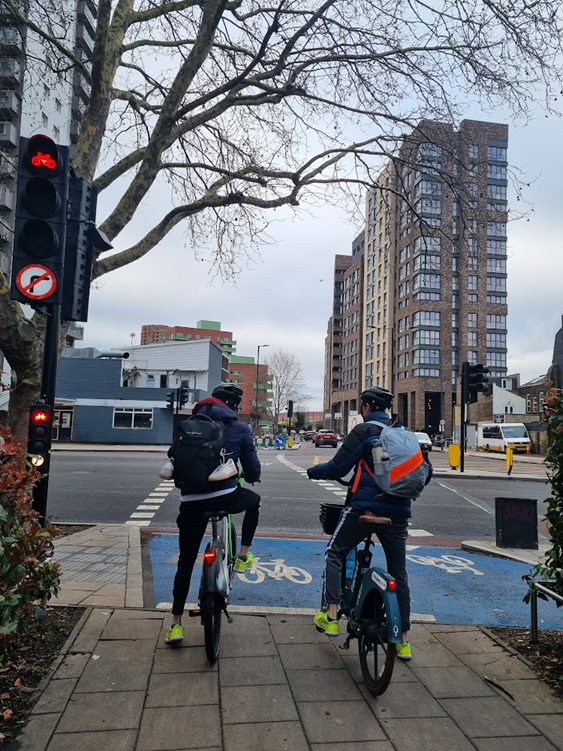 Two cyclists waiting to cross Old Kent Road at the redesigned junction to join the new link.
