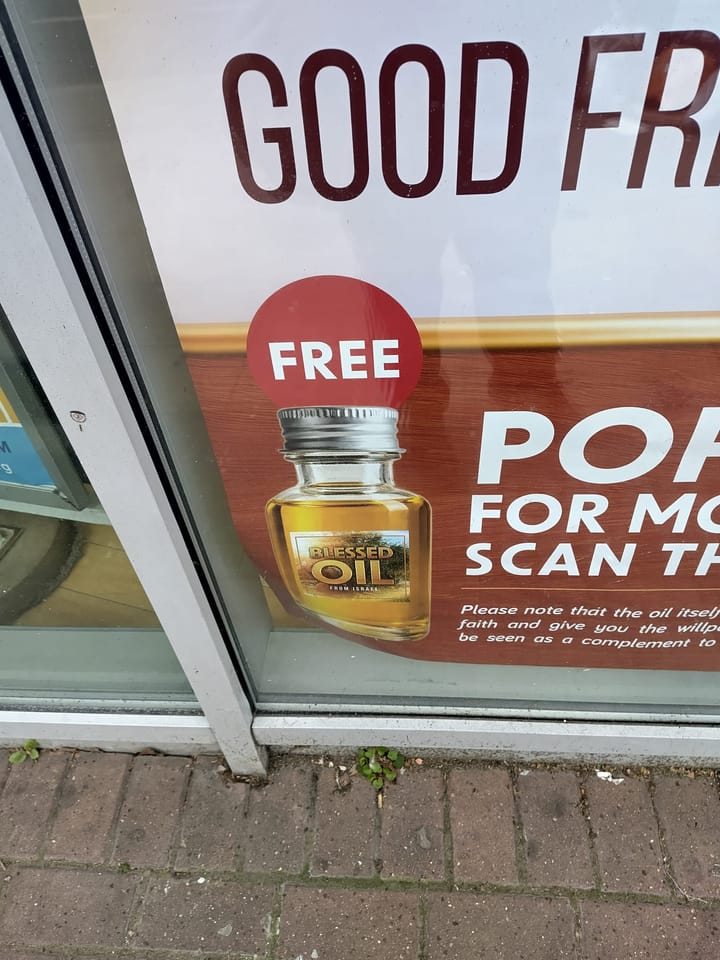 Corner of poster outside UCKG in Peckham advertising "Free Blessed oil" with picture of oil.