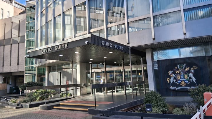 Lewisham Town Hall, 1980s glass office building with covered foyer and traditional crest on one wall. 