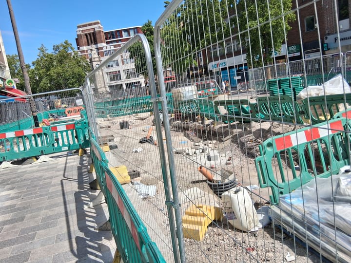 Fencing and barriers around parade outside Lewisham Shopping Centre, with construction in progress