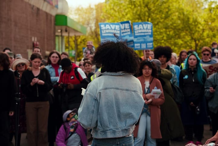 Speaker addresses rally with posters Save Lewisham Shopping Centre
